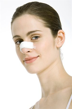 simsearch:695-03379049,k - Jeune femme avec un bandage sur le nez, souriant à la caméra, portrait Photographie de stock - Premium Libres de Droits, Code: 695-03379526