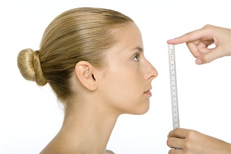 Woman in profile, face being measured by ruler Stock Photo - Premium Royalty-Free, Code: 695-03379537