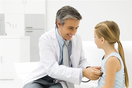 simsearch:695-03378815,k - Médecin écoute au coeur de la fillette avec stéthoscope, souriant Photographie de stock - Premium Libres de Droits, Code: 695-03379554