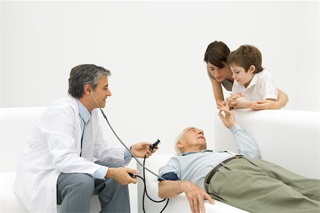 doctor measuring boy - Doctor measuring elderly man's blood pressure, family watching Stock Photo - Premium Royalty-Free, Code: 695-03379556