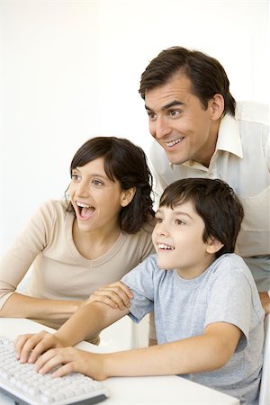 simsearch:632-02744824,k - Little boy playing computer video game while his parents watch, all smiling Foto de stock - Sin royalties Premium, Código: 695-03379705
