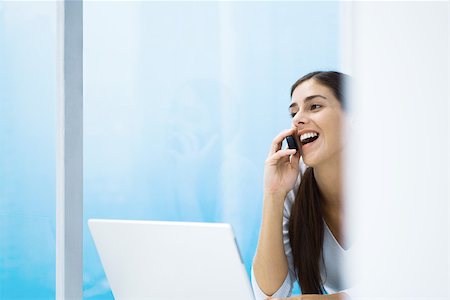 simsearch:695-03380514,k - Woman talking on cell phone, smiling, laptop, cropped Stock Photo - Premium Royalty-Free, Code: 695-03379749
