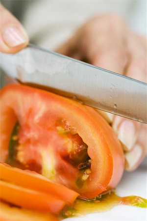 simsearch:632-03754635,k - Woman slicing tomato with knife, cropped view of hand Stock Photo - Premium Royalty-Free, Code: 695-03379756