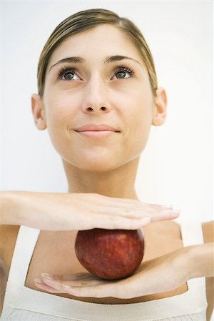 simsearch:633-01992708,k - Woman balancing apple between hands, looking up, cropped Stock Photo - Premium Royalty-Free, Code: 695-03379768