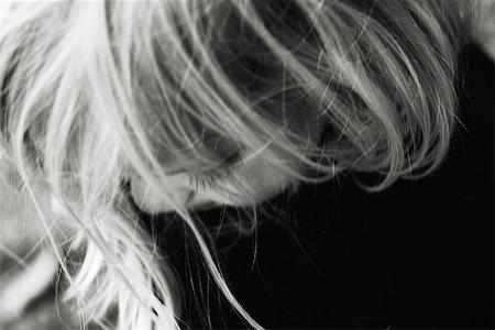 Little girl looking down, hair in front of face, cropped portrait Stock Photo - Premium Royalty-Free, Code: 695-03379817