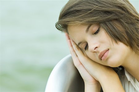 female teen sleep - Teenage girl resting head on clasped hands, eyes closed, close-up Stock Photo - Premium Royalty-Free, Code: 695-03379826