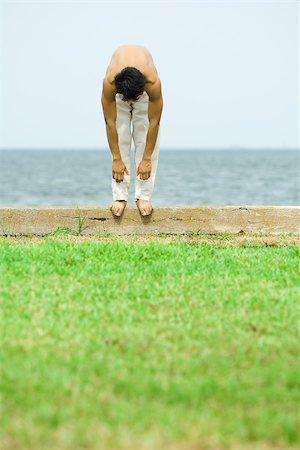 simsearch:695-03373919,k - Man standing on low wall outdoors, bending over Stock Photo - Premium Royalty-Free, Code: 695-03379828