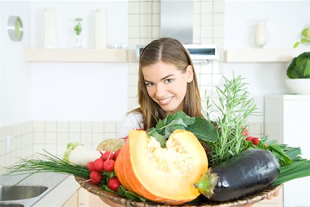 simsearch:695-03378760,k - Woman holding tray of fresh vegetables, smiling at camera Foto de stock - Sin royalties Premium, Código: 695-03379841