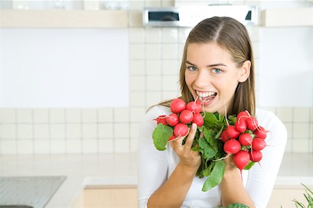 simsearch:695-03378760,k - Woman holding up bunches of fresh radishes, smiling at camera Foto de stock - Sin royalties Premium, Código: 695-03379842
