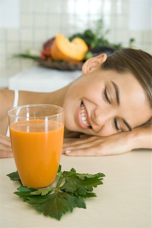 parts of human body female - Woman resting head on counter, looking at glass of vegetable juice, smiling Stock Photo - Premium Royalty-Free, Code: 695-03379853