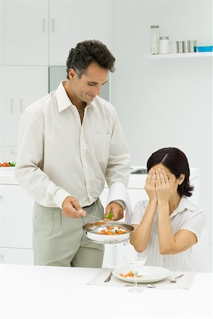 Husband serving wife surprise meal, woman covering eyes with hands Stock Photo - Premium Royalty-Free, Code: 695-03379880