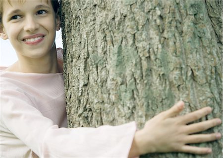 simsearch:696-03401960,k - Girl with arm around tree, smiling Stock Photo - Premium Royalty-Free, Code: 695-03373370