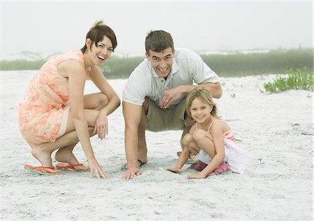 simsearch:696-03397536,k - Family at the beach, playing in the sand, smiling at camera Stock Photo - Premium Royalty-Free, Code: 695-03373513