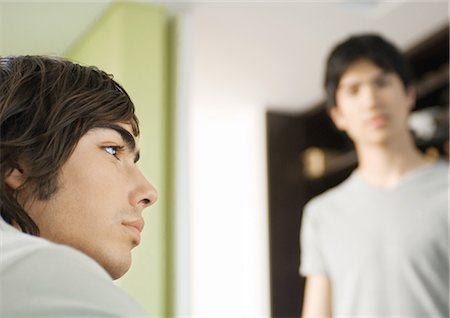 simsearch:6108-06166369,k - Young man looking away, friend in background Stock Photo - Premium Royalty-Free, Code: 695-03373543