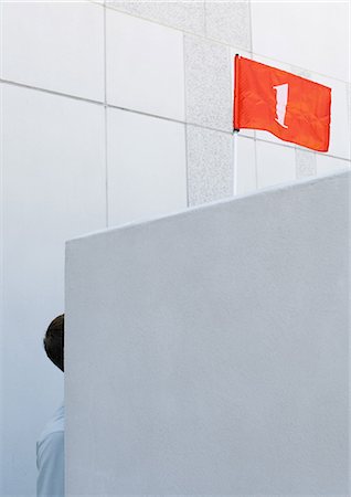 Partie de l'homme visible derrière le mur et d'un drapeau rouge avec une surcharge numéro « 1 » Photographie de stock - Premium Libres de Droits, Code: 695-03373629