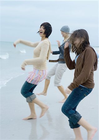 reversing - Three young women running toward surf Stock Photo - Premium Royalty-Free, Code: 695-03373851