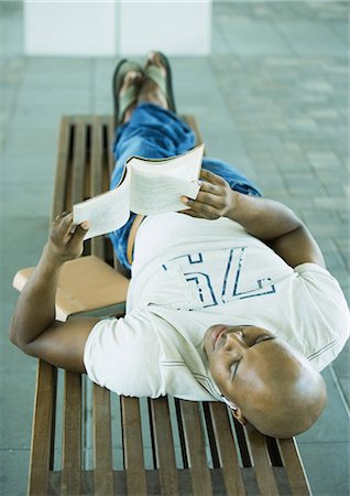 Male student lying on bench, reading Stock Photo - Premium Royalty-Free, Code: 695-03373905