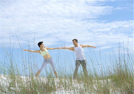 floridian - Man and woman doing side stretches on beach Stock Photo - Premium Royalty-Free, Code: 695-03373928