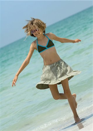 summer beach break - Girl stepping out of surf Stock Photo - Premium Royalty-Free, Code: 695-03373990