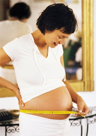 diffuse - Pregnant woman measuring her stomach Stock Photo - Premium Royalty-Free, Code: 695-03384027