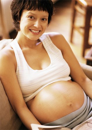 short haired women pregnant - Pregnant woman sitting in armchair, smiling at camera, portrait Stock Photo - Premium Royalty-Free, Code: 695-03384020