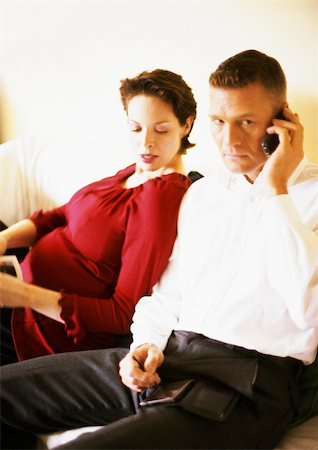 delivery mobile - Pregnant woman sitting with man using cell phone Stock Photo - Premium Royalty-Free, Code: 695-03384038