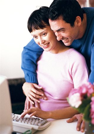 simsearch:632-01140106,k - Pregnant woman using computer, man with arms around her looking over her shoulder Stock Photo - Premium Royalty-Free, Code: 695-03384030