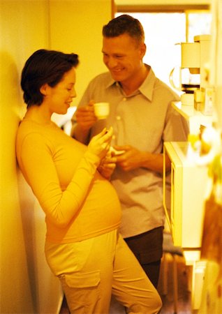 simsearch:632-01140071,k - Man and pregnant woman in kitchen, smiling, yellow tone Foto de stock - Sin royalties Premium, Código: 695-03384045