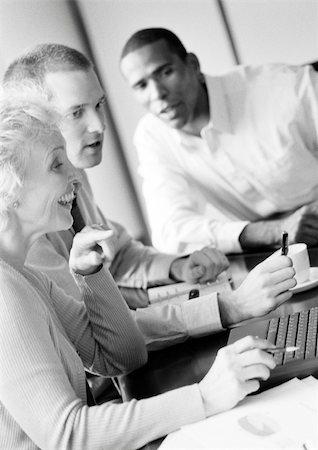 simsearch:695-05769165,k - Mature businesswoman in conference, smiling, profile, with two businessmen, B&W Stock Photo - Premium Royalty-Free, Code: 695-03384075