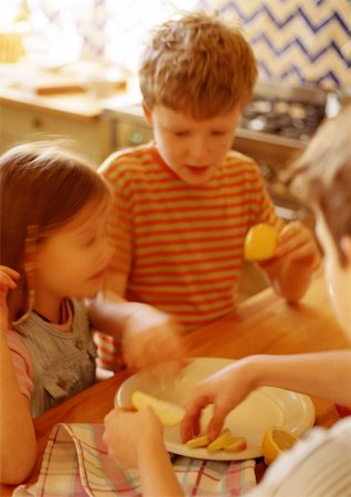 simsearch:695-03384582,k - Children in kitchen putting apple slices on plate, blurred Stock Photo - Premium Royalty-Free, Code: 695-03384571