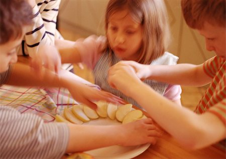 simsearch:649-06165319,k - Children arranging apple slices on plate, blurred motion Stock Photo - Premium Royalty-Free, Code: 695-03384589