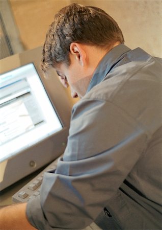 disheartening - Man working on computer, rear view Stock Photo - Premium Royalty-Free, Code: 695-03384667