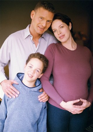 simsearch:695-03384752,k - Pregnant woman and man standing with child, smiling, portrait Foto de stock - Royalty Free Premium, Número: 695-03384774