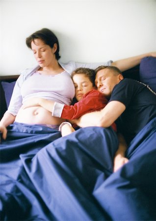 Pregnant woman, man and child in bed together Stock Photo - Premium Royalty-Free, Code: 695-03384784