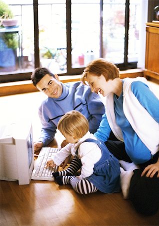 simsearch:696-03402790,k - Pregnant woman and man on floor with child touching computer keyboard Stock Photo - Premium Royalty-Free, Code: 695-03384800