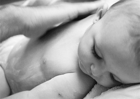 simsearch:695-03384924,k - Adult hand rubbing lotion into baby's chest, close-up, b&w Foto de stock - Royalty Free Premium, Número: 695-03384939