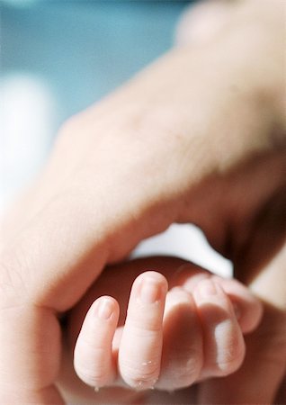 simsearch:695-03384924,k - Adult's hand holding baby's hand, close-up Foto de stock - Royalty Free Premium, Número: 695-03384943