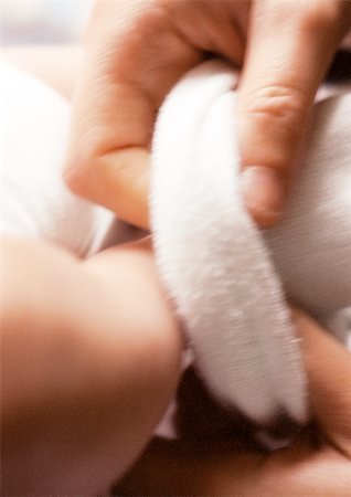 simsearch:695-03384924,k - Adult hand dressing baby, close-up Foto de stock - Royalty Free Premium, Número: 695-03384968