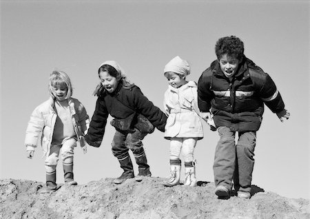 simsearch:695-05777236,k - Three girls and boy holding hands, preparing to jump, b&w Fotografie stock - Premium Royalty-Free, Codice: 695-03385098