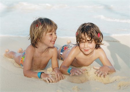 simsearch:695-05773921,k - Deux jeunes filles se trouvant sur le sable à la plage, sourire Photographie de stock - Premium Libres de Droits, Code: 695-03385104