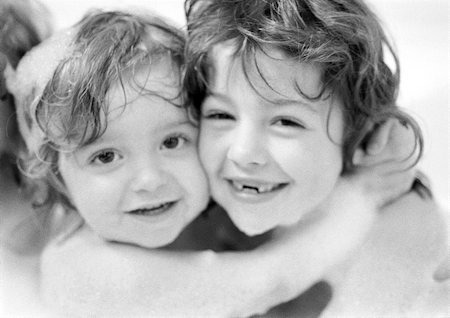 Two girls hugging in bathtub, portrait, b&w Stock Photo - Premium Royalty-Free, Code: 695-03385102