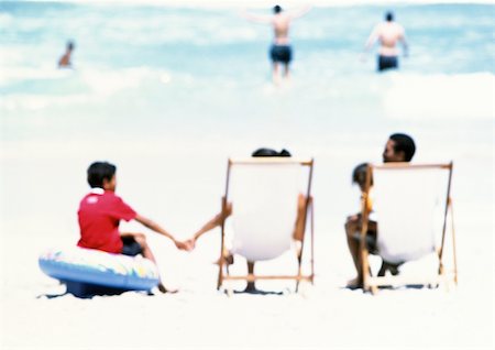 Family sitting on beach, rear view Stock Photo - Premium Royalty-Free, Code: 695-03385212