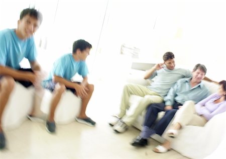 Family sitting in living room, blurred Stock Photo - Premium Royalty-Free, Code: 695-03385325