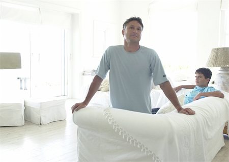 parents fighting - Man on teenage boy in living room, man looking at camera Stock Photo - Premium Royalty-Free, Code: 695-03385327