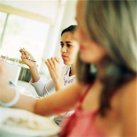 sibling sad - Girls eating, blurred foreground Stock Photo - Premium Royalty-Free, Code: 695-03385408