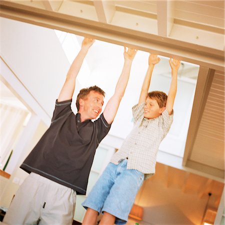 simsearch:695-03385136,k - Father and son reaching to touch ceiling beam, smiling Stock Photo - Premium Royalty-Free, Code: 695-03385403