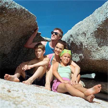 family shelter - Parents and children sitting between rocks, portrait Stock Photo - Premium Royalty-Free, Code: 695-03385417