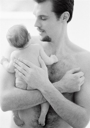 father holding a baby in his hands - Topless father holding infant, patting infant's back, b&w Stock Photo - Premium Royalty-Free, Code: 695-03385501