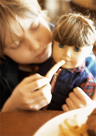 Little girl feeding doll, portrait. Stock Photo - Premium Royalty-Free, Code: 695-03385637