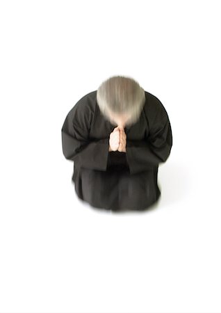 simsearch:695-03385803,k - Man kneeling on floor, hands together, blurred motion Stock Photo - Premium Royalty-Free, Code: 695-03385804